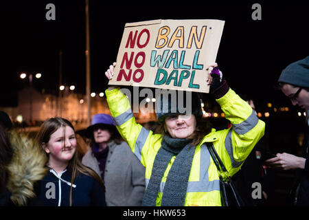 PROTESTING AGAINST DONALD TRUMP: Aberystwyth, Wales, UK. 30th Jan, 2017. Around 300 people of all ages and from a wide range of backgrounds gathered, many carrying banners, outside the seaside bandstand in Aberystwyth at 6pm tonight, Monday 30 Jan, to protest against the Executive Order signed by President Donald Trump banning entry into the USA for refugees from Syria and other people from seven primarily Muslim countries in the middle east photo Credit: keith morris/Alamy Live News Stock Photo