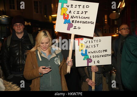 Brighton, UK. 30th January, 2017. Two women holding placards reading 'Twisted Racist Unwelcome Misogynistic Pig' are part of the crowd of people in the square and streets around Brighton's town Hall, in protest against the immigration laws introduced by Donald Trump in the USA. Credit: Roland Ravenhill/Alamy Live News Stock Photo