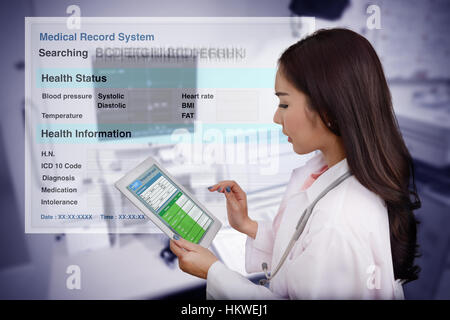 Female doctor searching patient information from medical record system by using tablet computer. Stock Photo
