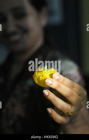 Lady smiling holding chaat towards camera Stock Photo