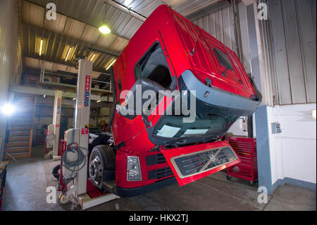 Volvo cab-over HGV truck in a workshop, cab flipped forward to work on the engine Stock Photo