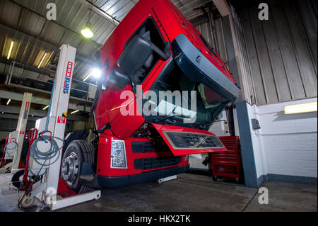 Volvo cab-over HGV truck in a workshop, cab flipped forward to work on the engine Stock Photo