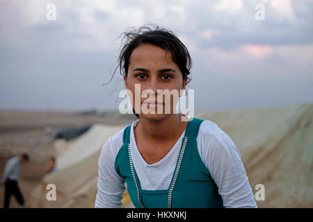 A young displaced woman from the minority Yazidi sect in Nawroz refugee camp which was initially established to shelter Syrians displaced from the ongoing Syrian civil war then occupied by displaced people from the minority Yazidi sect, fleeing the violence in the Iraqi town of Sinjar situated next to the town of al-Malikyah in Rojava autonomous Kurdish region, North Eastern Syria. Stock Photo