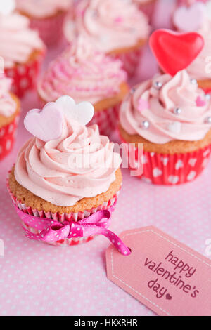 Pink Valentine cupcakes with the words 'Happy Valentine's day' on a tag. Stock Photo