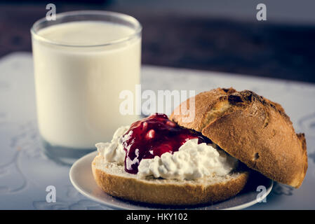 Glass of milk, fresh tasty sandwich make of cut roll, cottage cheese and jam Stock Photo