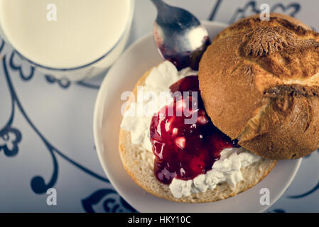 Glass of milk, fresh tasty sandwich make of cut roll, cottage cheese and jam Stock Photo