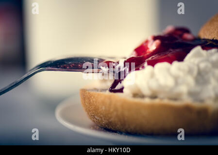 Glass of milk, fresh tasty sandwich make of cut roll, cottage cheese and jam. Close up Stock Photo