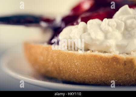 Close up of fresh tasty sandwich make of cut roll, cottage cheese and jam. Stock Photo