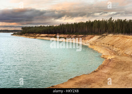 Sand quarry with blue lake under the magnificient sky. Stock Photo