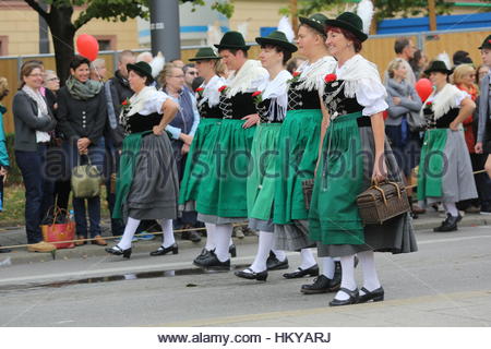 Women dressed in traditional dresses known as dirndls walk during the Oktoberfest parade. Stock Photo