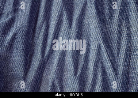 Close up picture of wrinkly blue jeans fabric background or texture. Stock Photo