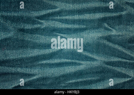 Color toned close up picture of wrinkly jeans fabric background or texture. Stock Photo