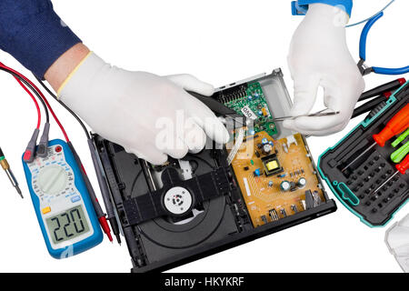 Repair of the  modern dvd player in the professional service center. Repair man uses the antistatic equipment. Isolated with patch. No brands or logos Stock Photo