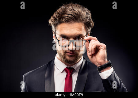 Businessman adjusting eyeglasses Stock Photo