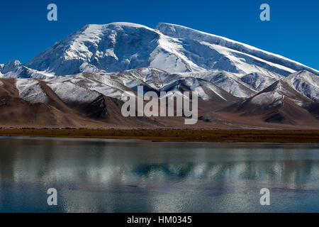 Muztagh Ata, or Muztagata by Karakul Lake by the Karakoram Highway, Xinjiang Autonomous Region, China. Stock Photo
