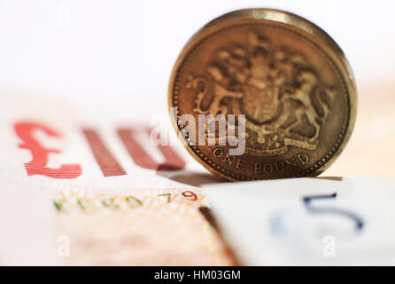 A one pound coin placed between a five pound and ten pound banknote in north London. PRESS ASSOCIATION Photo. Picture date: Sunday January 29, 2017. Photo credit should read: Yui Mok/PA Wire Stock Photo