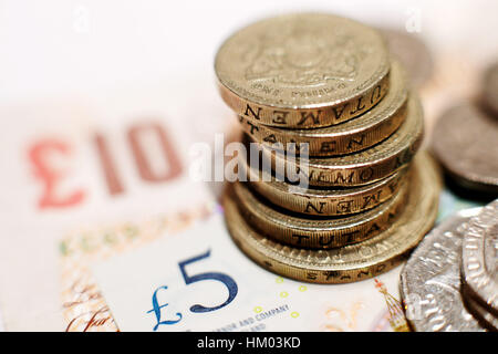 A pile of one pound coins placed on five pound and ten pound banknotes in north London. PRESS ASSOCIATION Photo. Picture date: Sunday January 29, 2017. Photo credit should read: Yui Mok/PA Wire Stock Photo