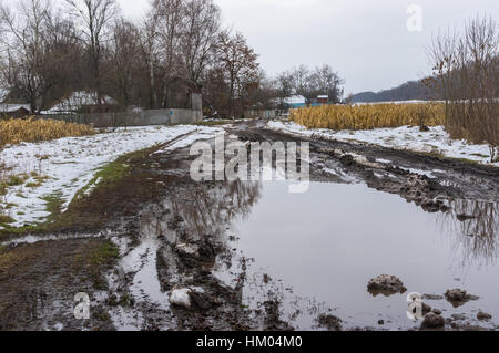 Rural landscape with dirty road leading to small Ukrainian village Padilky in Sumskaya oblast, Ukraine Stock Photo