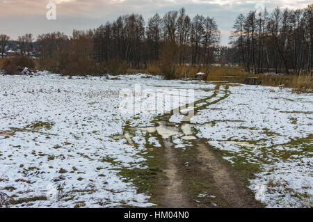 Winter rural landscape with an earth road leading to Hrun' river in Sumskaya oblast, Ukraine Stock Photo