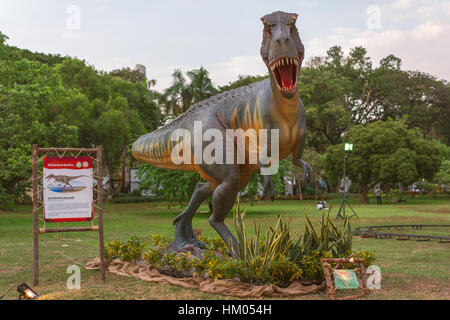 Dinosaur in the Park with green grass and trees Stock Photo