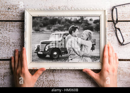 Hands holding black-and-white photo of seniors in picture frame Stock Photo