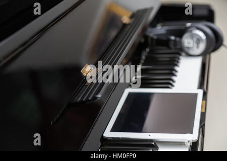 Tablet and head phones on Piano keys Stock Photo