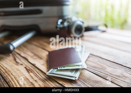 Blank passport and camera with US dollars on wood table Stock Photo