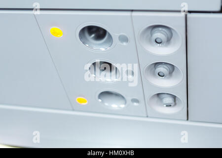 lights, air condition  signs panel above the seat on plane Stock Photo