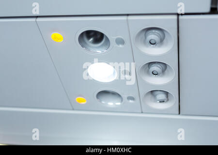 lights, air condition  signs panel above the seat on plane Stock Photo