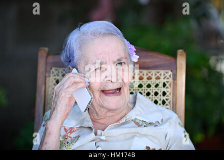 happy smiling grandma talk on white modern phone Stock Photo