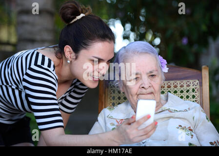 grandma look in white smartphone with grandchildren Stock Photo