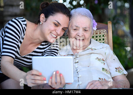 grandma and granddaughter taking a selfie with a tablet Stock Photo