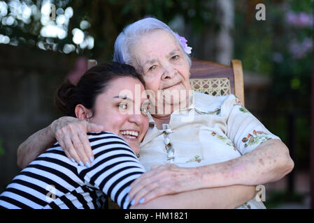 Grandma and grandaughter together hugging and laughing Stock Photo