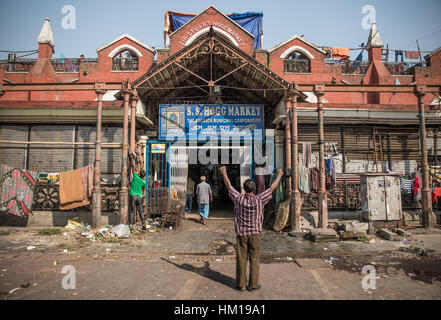 A man stretches outside New Market (formerly known as Hogg Market) in Kolkata (Calcutta), West Bengal, India. Stock Photo