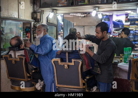 Barbers at work in New Market, formerly known as Hogg Market, in Kolkata (Calcutta), West Bengal, India. Stock Photo