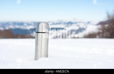 Thermos with a hot drink on mountain waterfall Stock Photo by