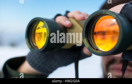 Man using binoculars outside on a winter day clsoe up Stock Photo
