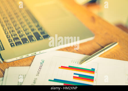 Financial charts on the table with laptop  ( Filtered image processed vintage effect. ) Stock Photo