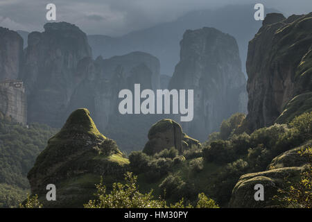 View over Roussanou Monastery, medieval 16th century nunnery, and the conglomerate pinnacles on a misty autumn evening;  Meteora, Greece, Stock Photo