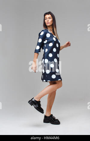 Model in blue dress with polka dots making steps Stock Photo