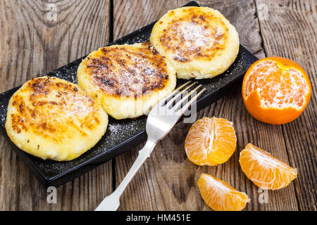 Hot sweet cheesecakes with tangerines and honey Stock Photo