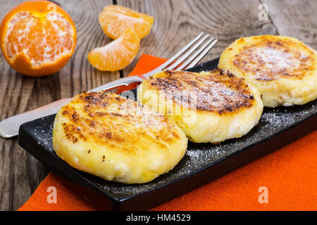 Hot sweet cheesecakes with tangerines and honey Stock Photo