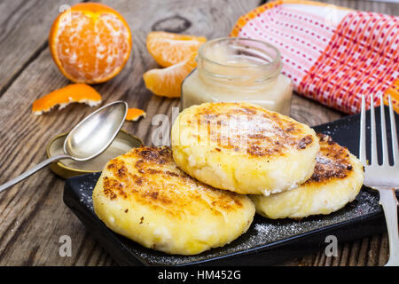 Hot sweet cheesecakes with tangerines and honey Stock Photo