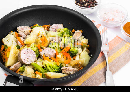 Vegetable stew with sausage grilled slices in a frying pan on a Stock Photo