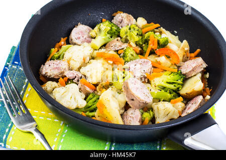 Vegetable stew with sausage grilled slices in a frying pan on a Stock Photo