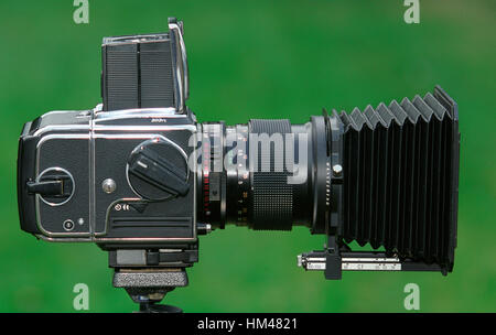 Medium format camera mounted on tripod ready for use - camera Hassleblad 203F with 150mm lens and professional lens hood. Stock Photo