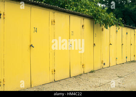 Several yellow numbered car garages. Photographed in the summer outdoors. Stock Photo