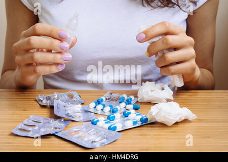 Woman holds a spray for rhinitis and napkins in her hands Stock Photo