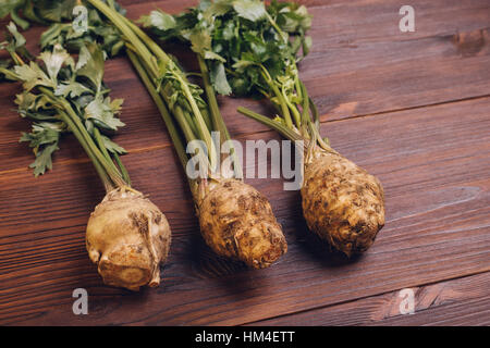 Celery with roots and leaves on wooden table, top view Stock Photo