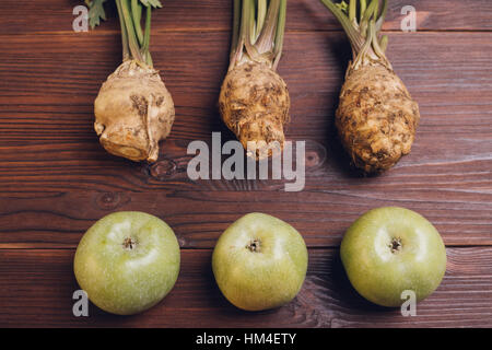 Celery with roots and leaves and green apples on the wooden table, top view Stock Photo